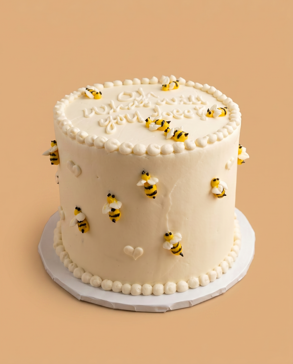 White buttercream bumble bee gender reveal cake with piped bees and 